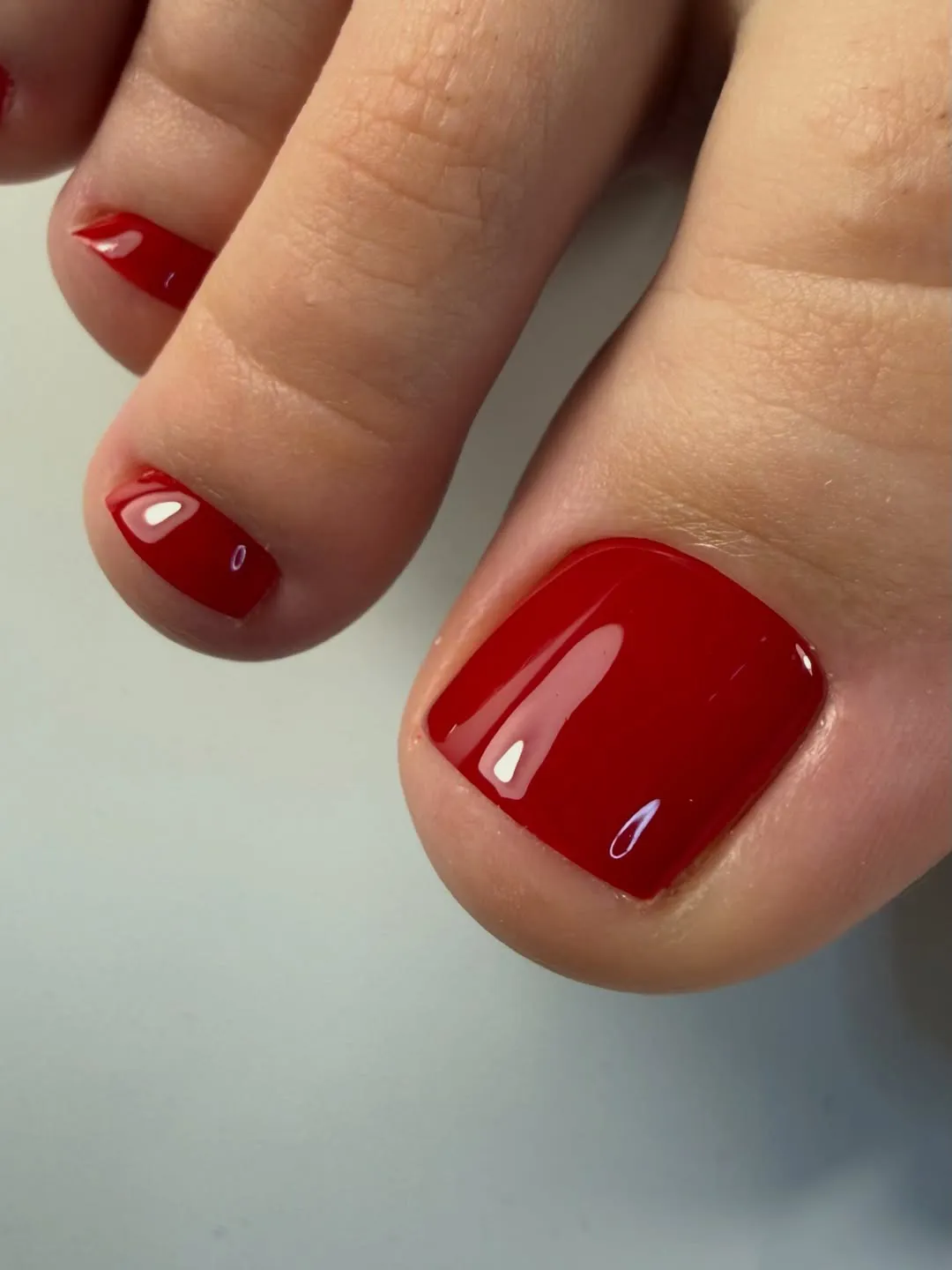 Pedikīrs ar spīdīgu sarkanu pārklājumu – Daiga Nails darbs